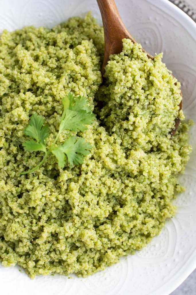 Photo of Quinoa With Cilantro Lime Sauce being served with a wooden spoon.