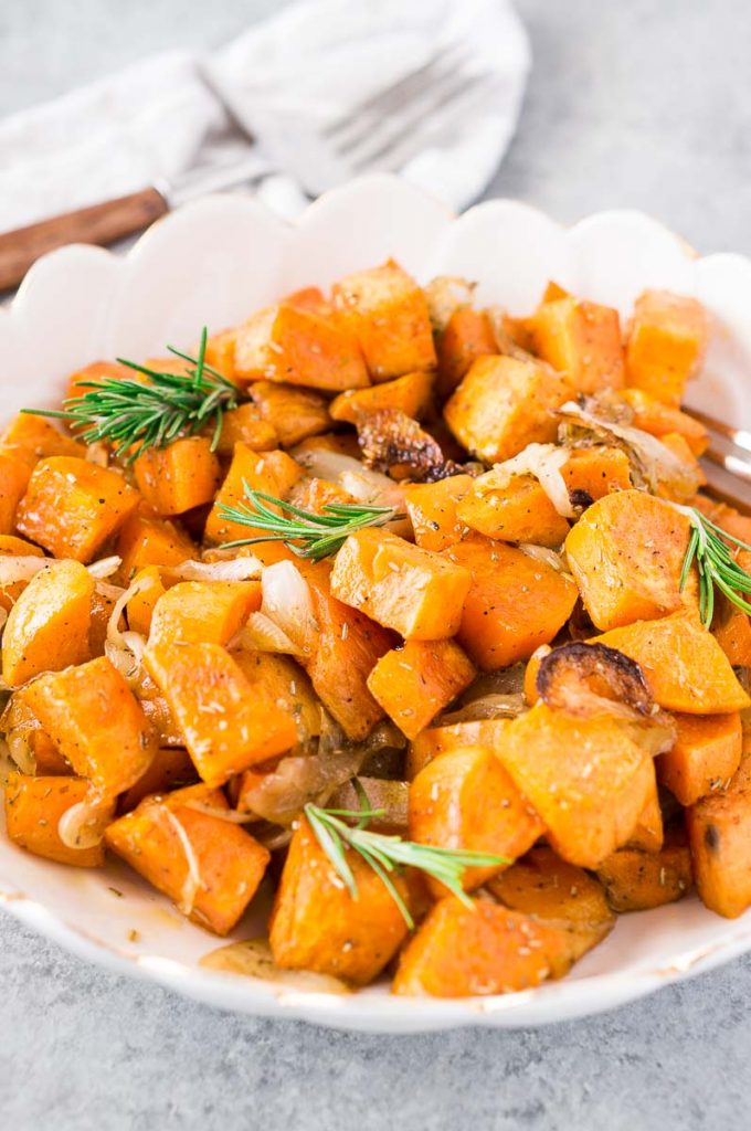 Photo of Roasted Sweet Potatoes and Onions being served in a scalloped white dish.