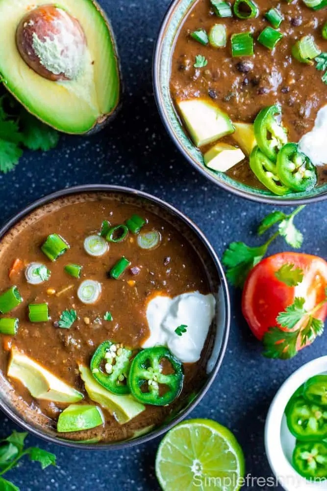 Photo of black bean soup being served in rustic bowls.