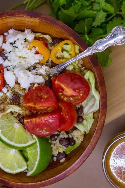 Photo of Southwest Salad With Quinoa & Black Beans being served in a wooden bowl.