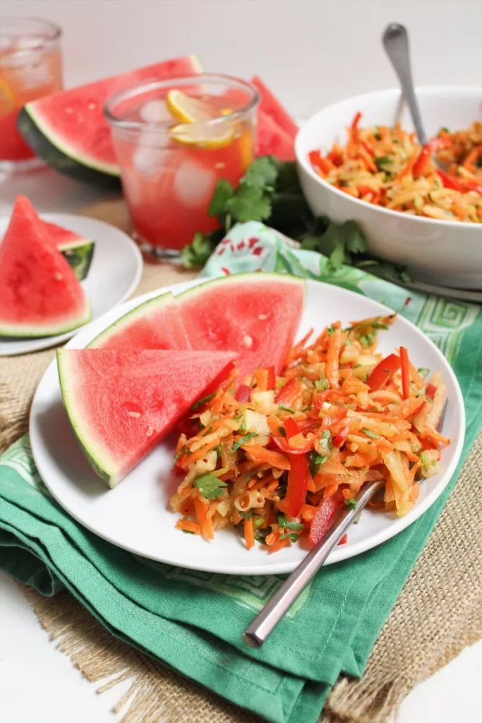 Photo of watermelon rind coleslaw being served with sliced watermelon.