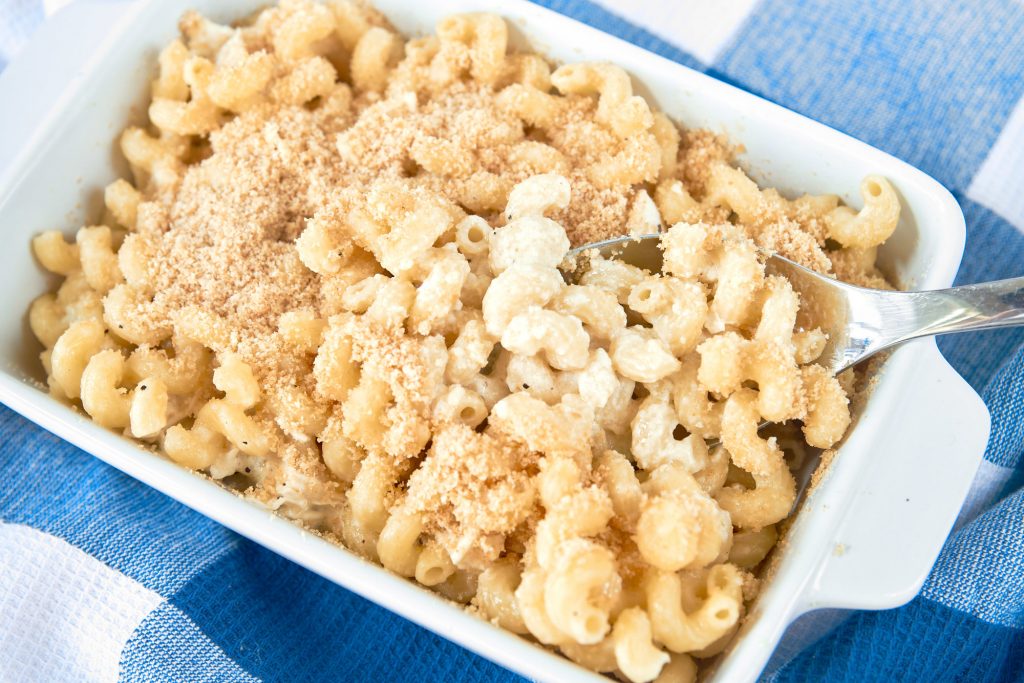 scooping out side of brie pasta from white baking dish