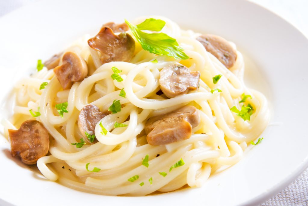 close up of mushroom cream pasta with parsley garnish