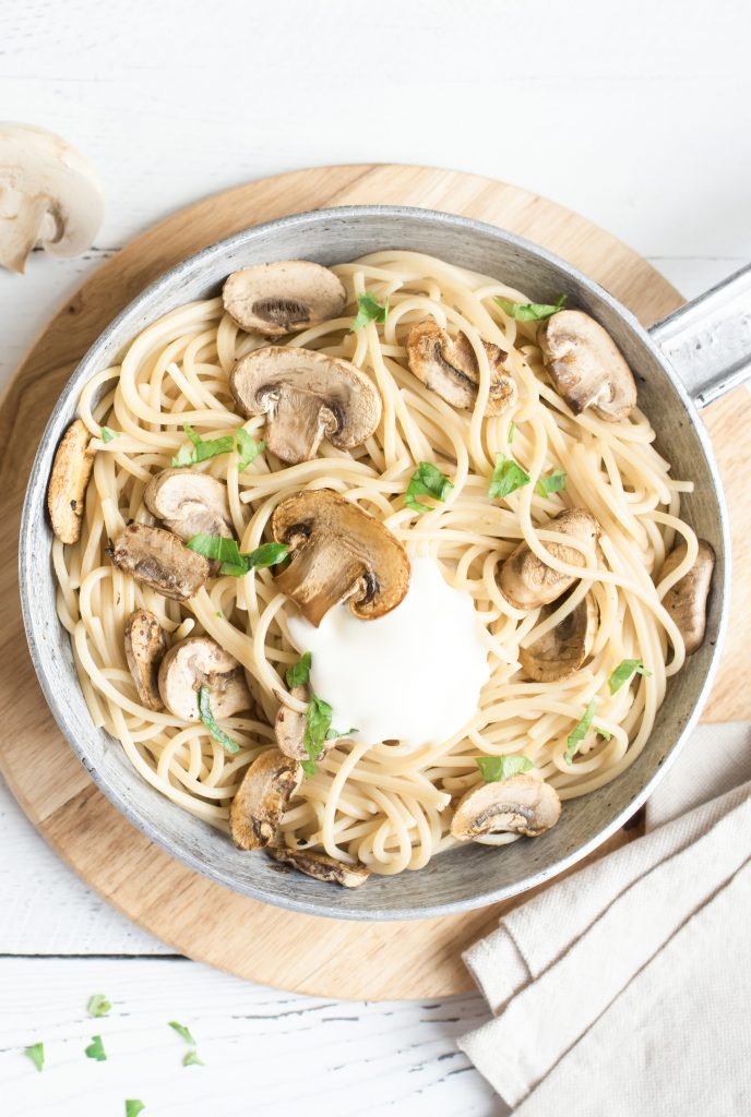 pasta and mushrooms in a pot with garlic cream