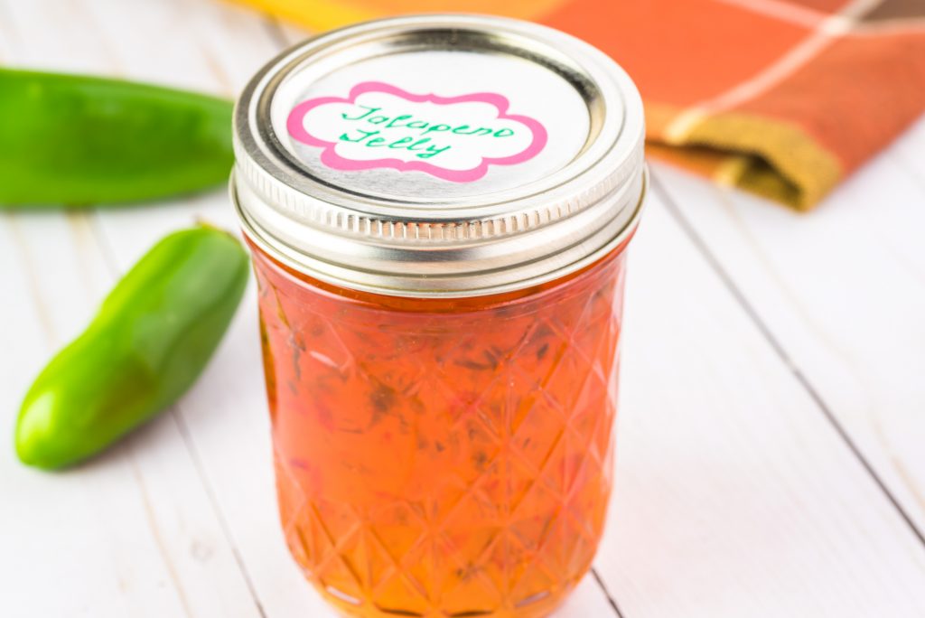 jalapeno jelly with jalapeno peppers in the background