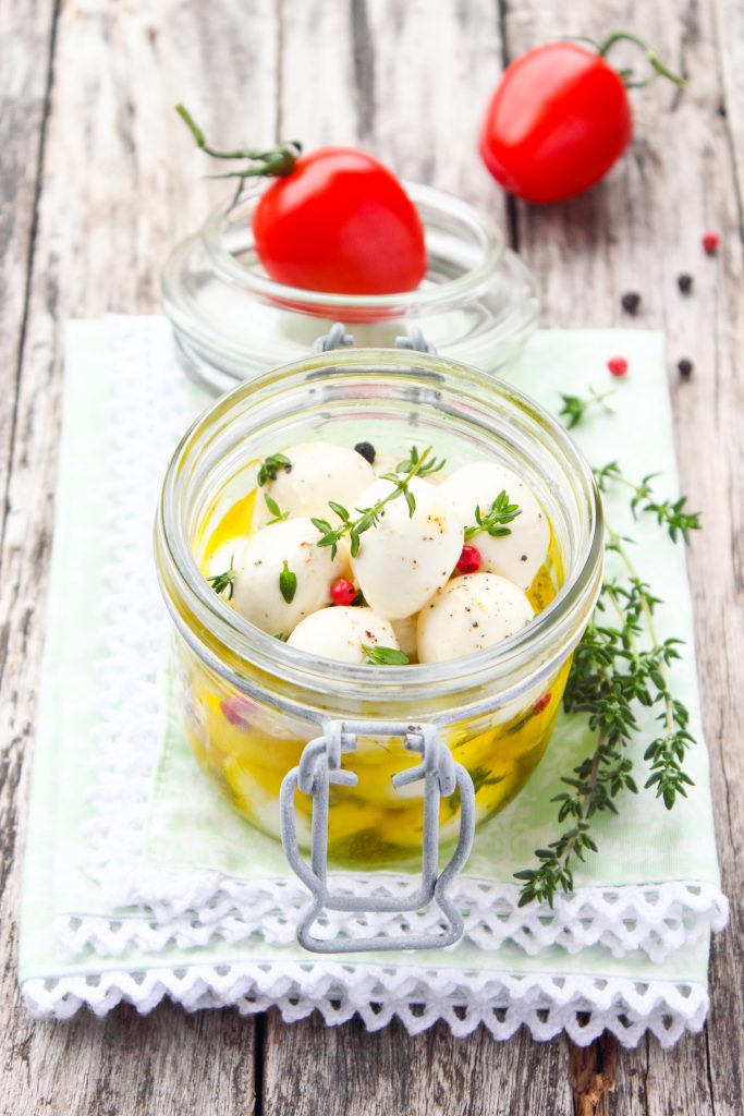 marinated mozzarella balls in a jar with tomatoes
