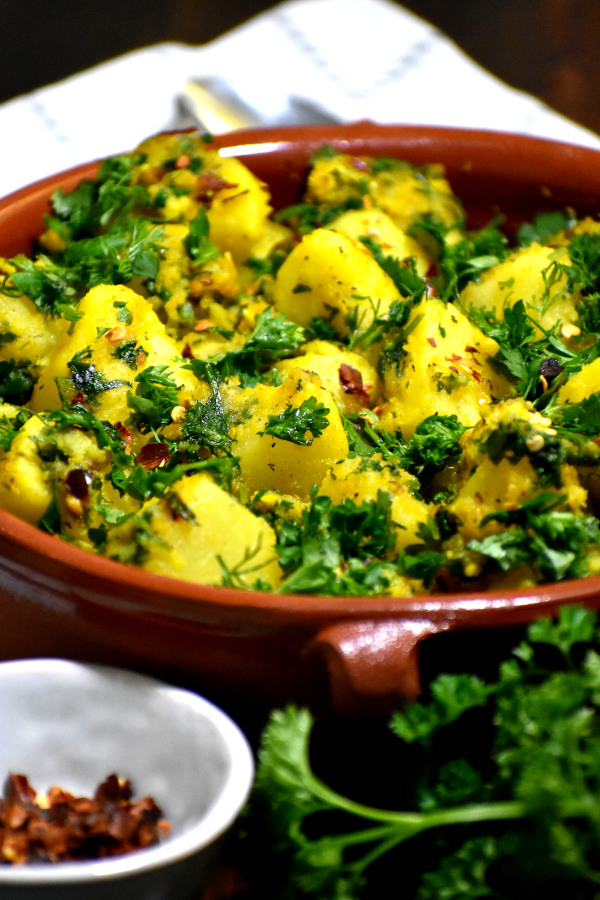 photo of Lebanese Batata Harra being served in a red bowl. 