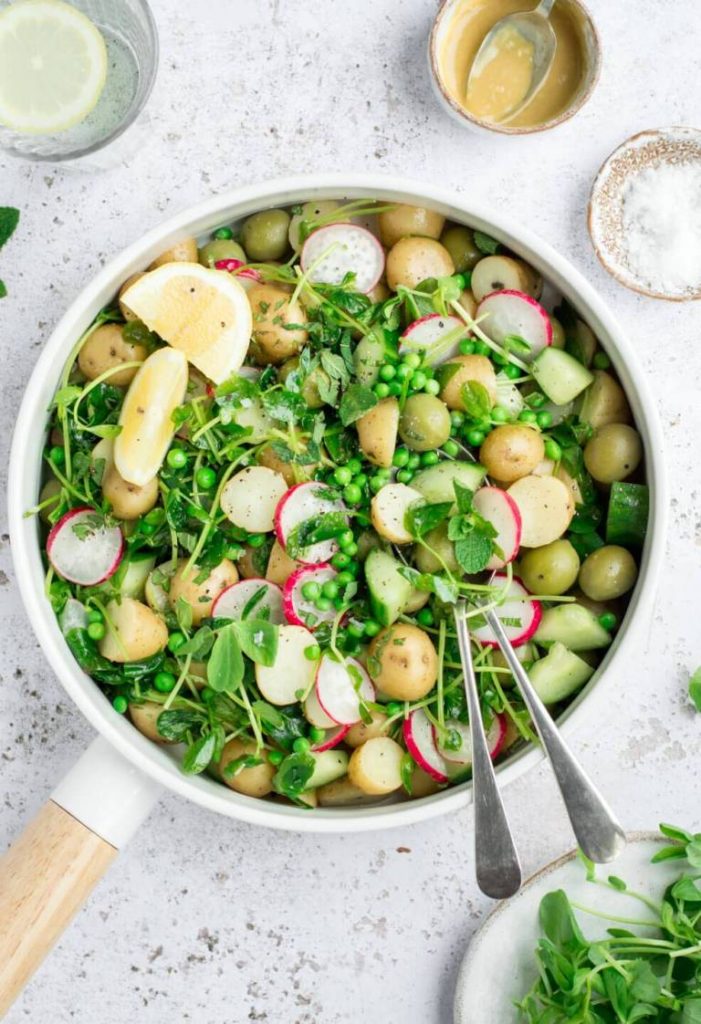 Photo of Vegan Potato Salad being served in a large pot with two spoons.