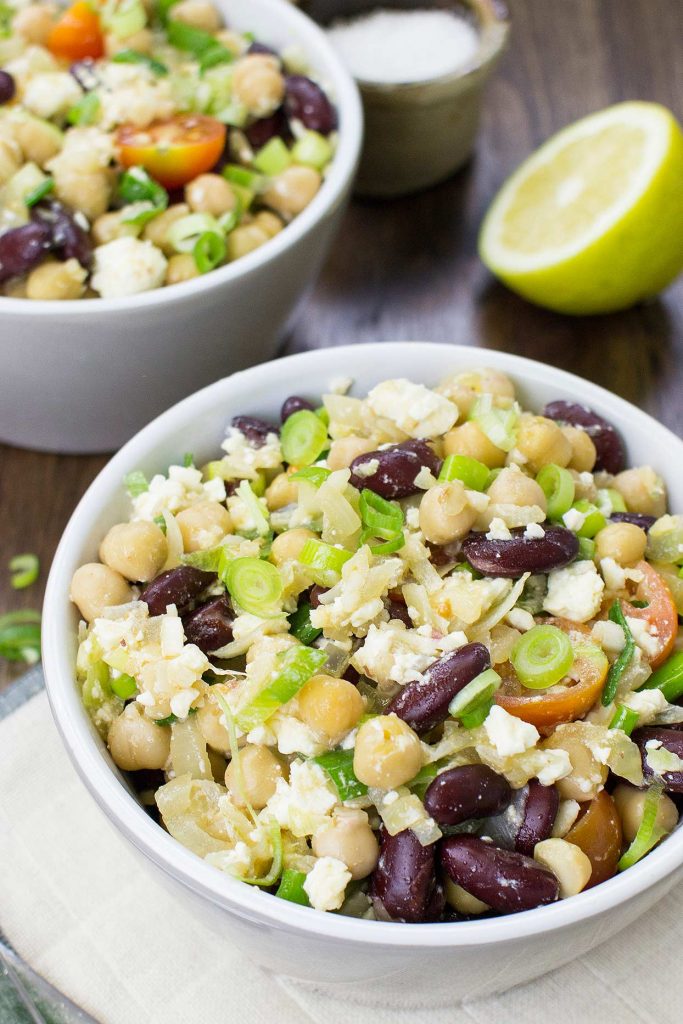 Photo of two small white bowls serving a simple chickpea salad. 