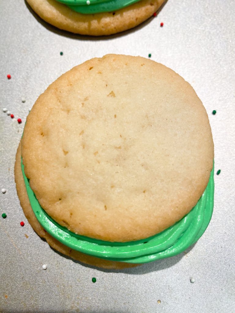 cookie stacked on green icing with sprinkles around it 
