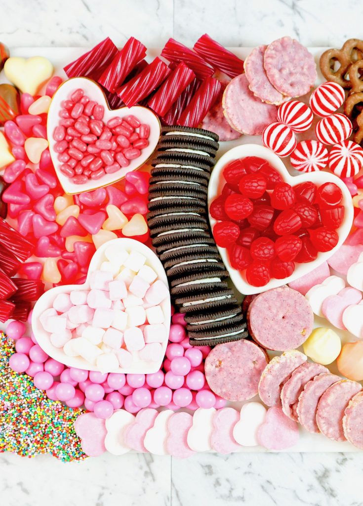 close up of a valentines day charcuterie board with cookies and candy