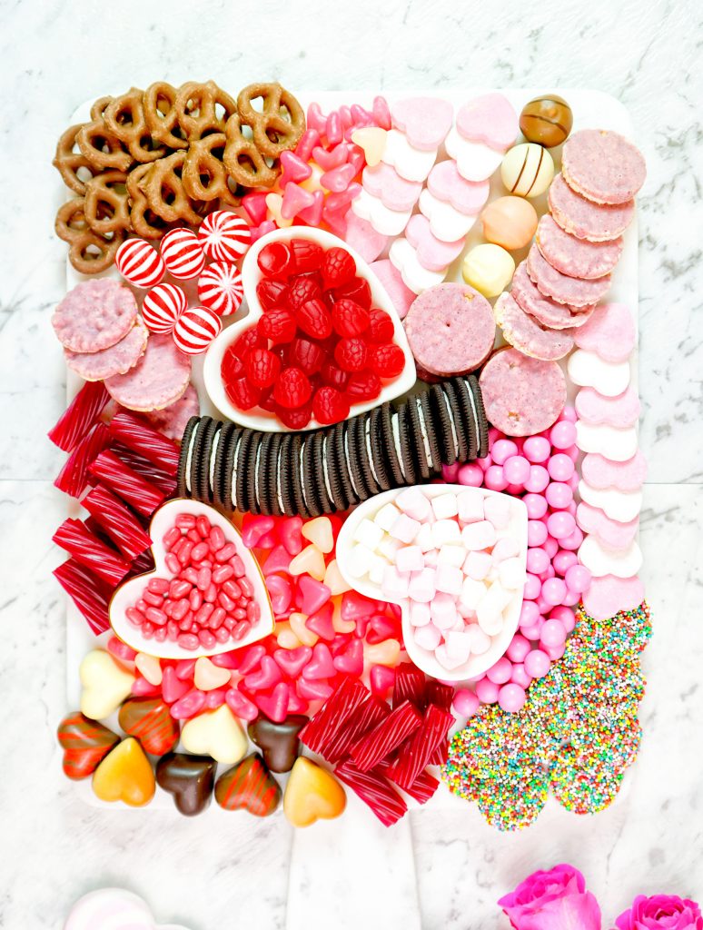 valentines day charcuterie board with lots of chocolate, candy, oreos and more