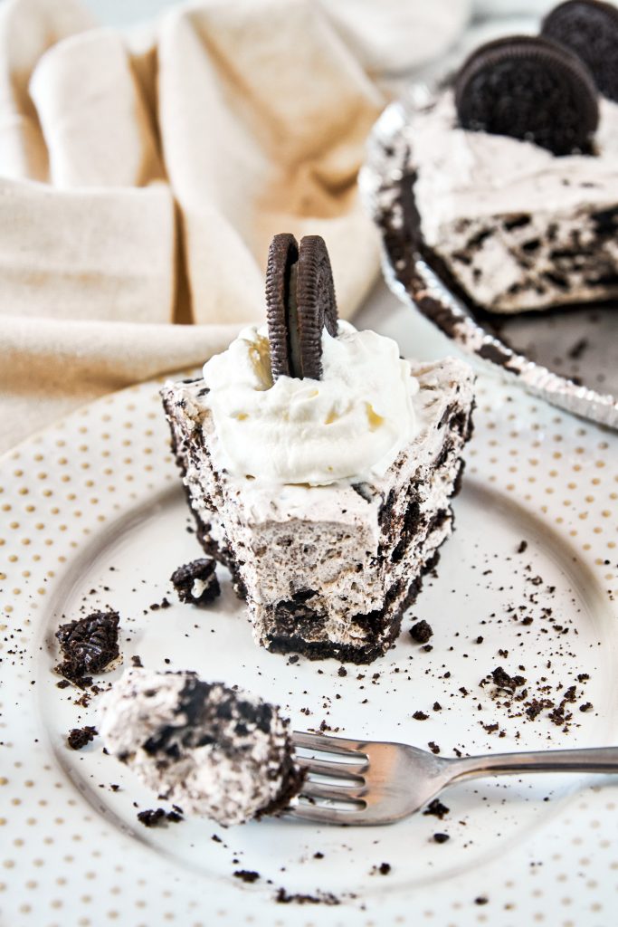 fork taking a slice out of a vegan Oreo cheesecake on a plate
