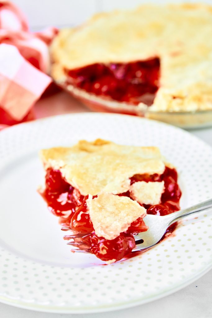 slice of vegan cherry pie with fork cutting it