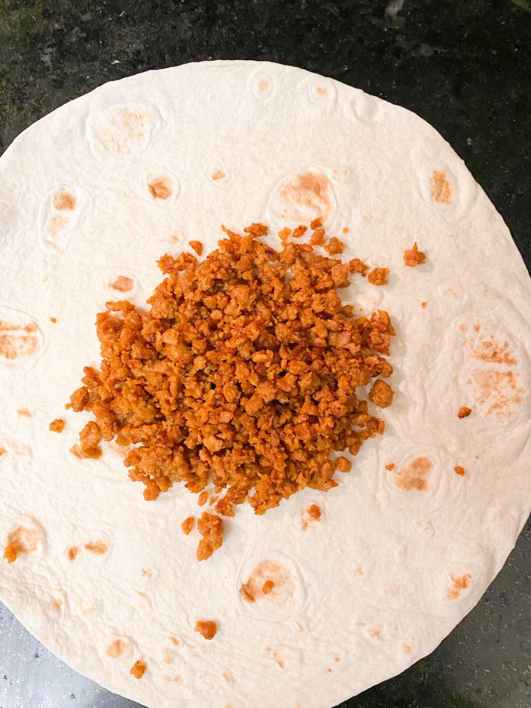 vegan beef crumbles on a large flour tortilla
