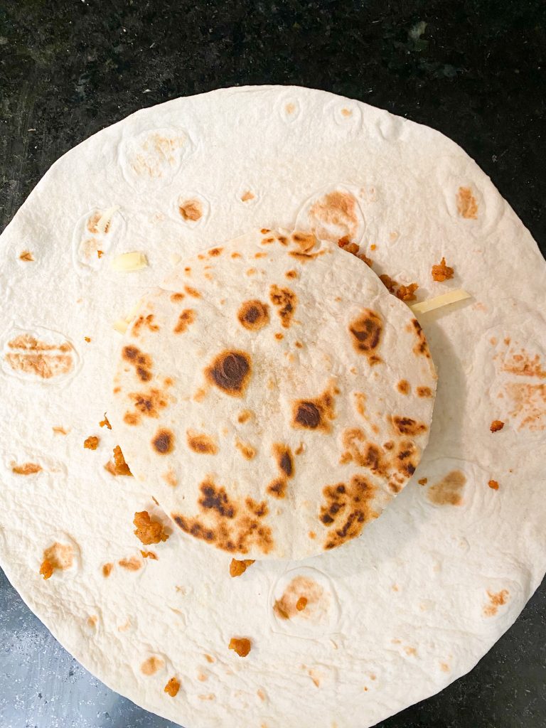 crispy tortilla on top of larger tortilla to make a vegan crunchwrap supreme