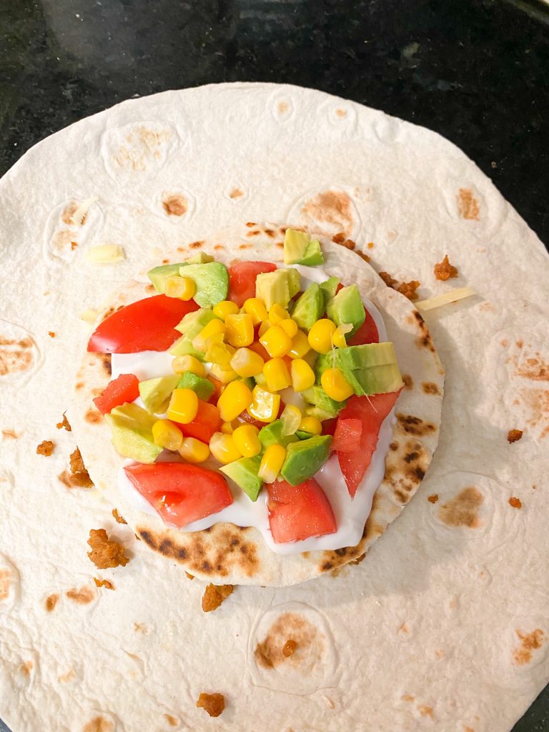 veggies on top of a tortilla with sour cream