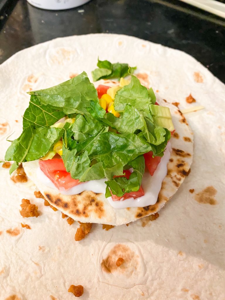 shredded lettuce and veggies on top of tortillas