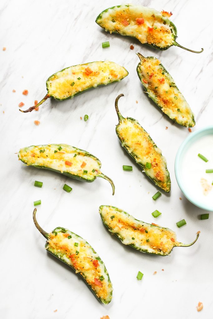 vegan jalapeno poppers on a counter with sour cream
