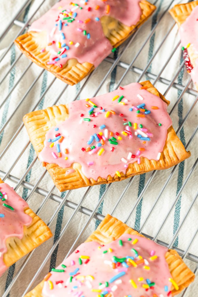 lots of vegan pop tarts on a cooling rack with dish towel