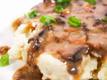 close up of vegan gravy with mushrooms over mashed potatoes