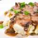 close up of vegan gravy with mushrooms over mashed potatoes