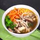 easy vegan udon noodle soup on black counter with green napkin