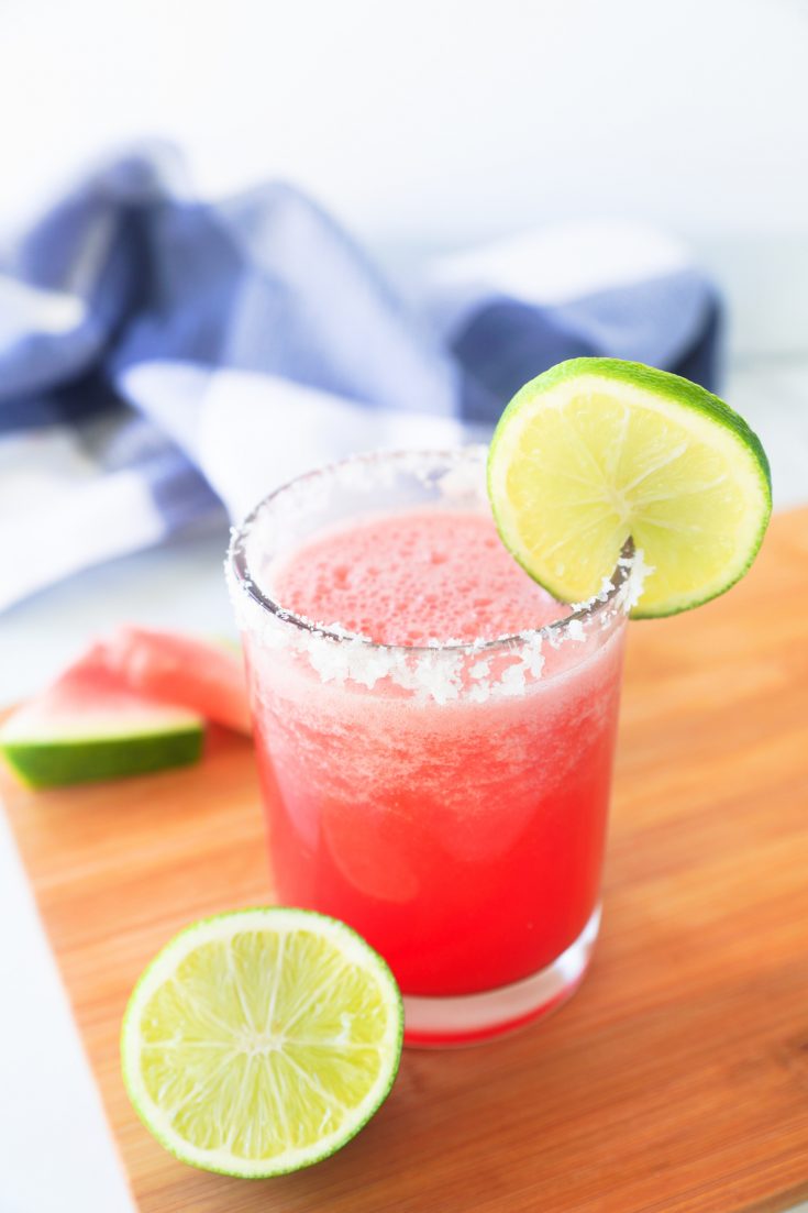 frozen watermelon margarita with fresh limes and blue towel