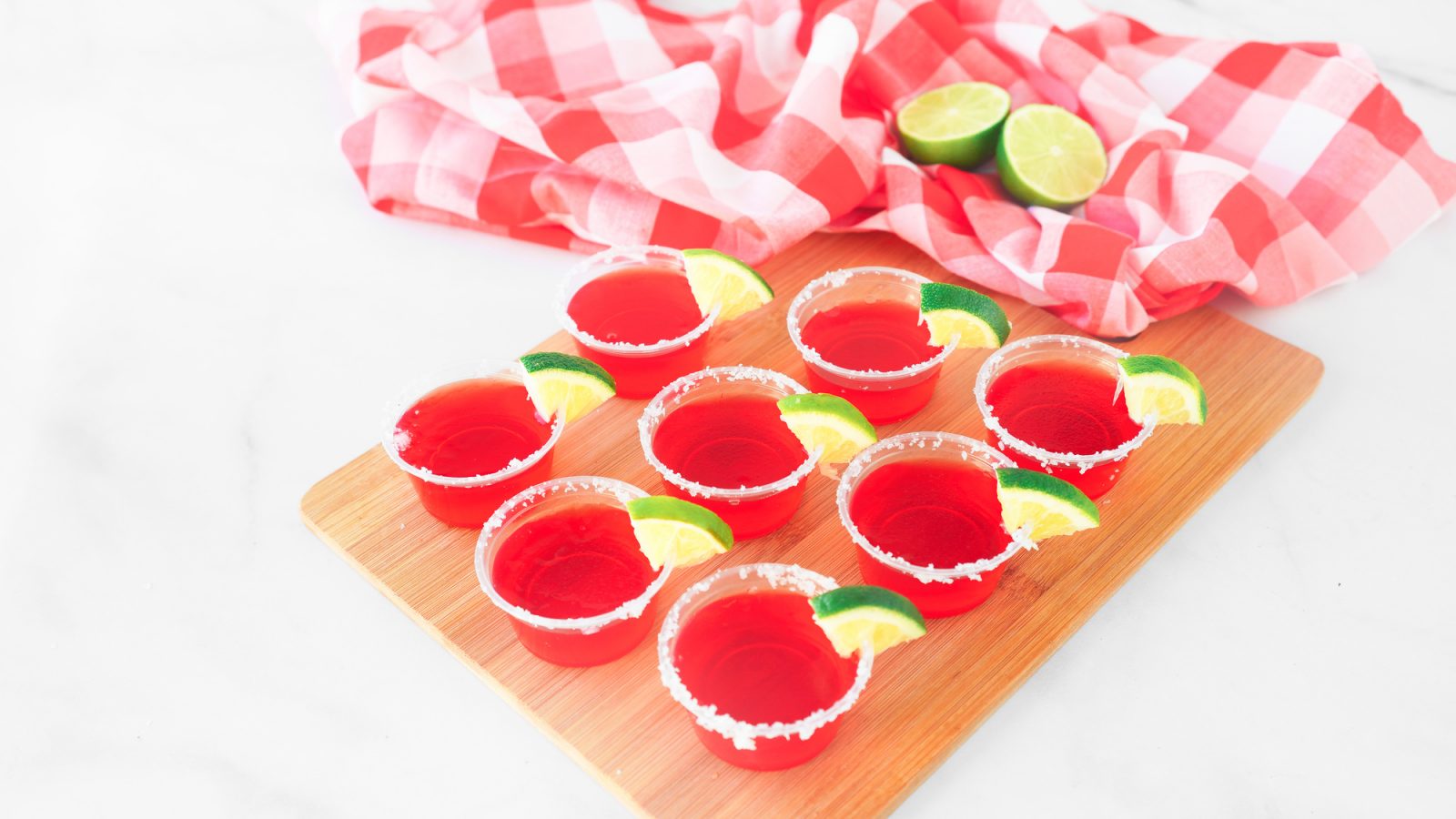 strawberry margarita vegan jello shots on tray with limes
