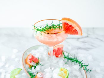 grapefruit cocktail on serving tray with crushed ice