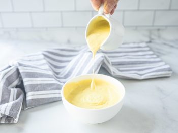 vegan hollandaise sauce being poured into a bowl