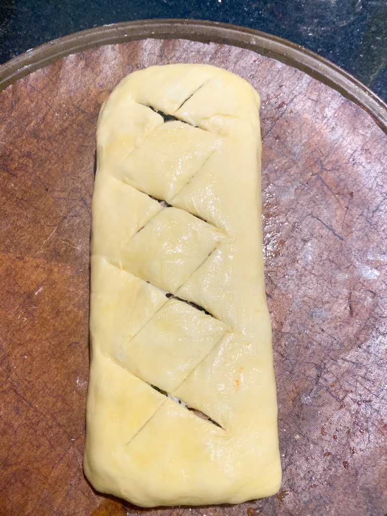 Top of folded uncooked vegan Wellington with cut x slits on top.
