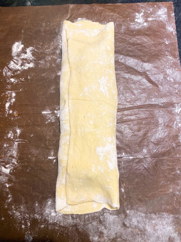 Puff pastry folded over the Wellington mixture.