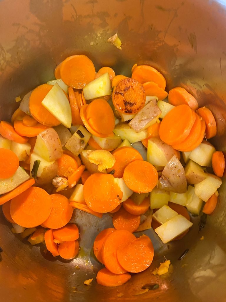 Chopped carrots and potatoes in a pot.