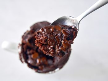 scoop of chocolate vegan mug cake being taken up with a spoon