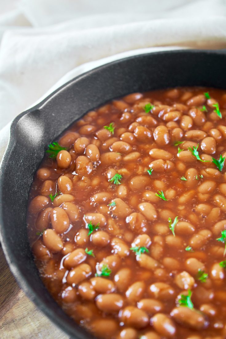 vegan baked beans in a cast iron skillet with parsley