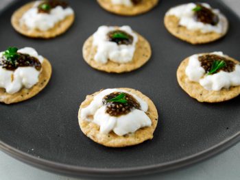 crackers topped with vegan caviar on a plate