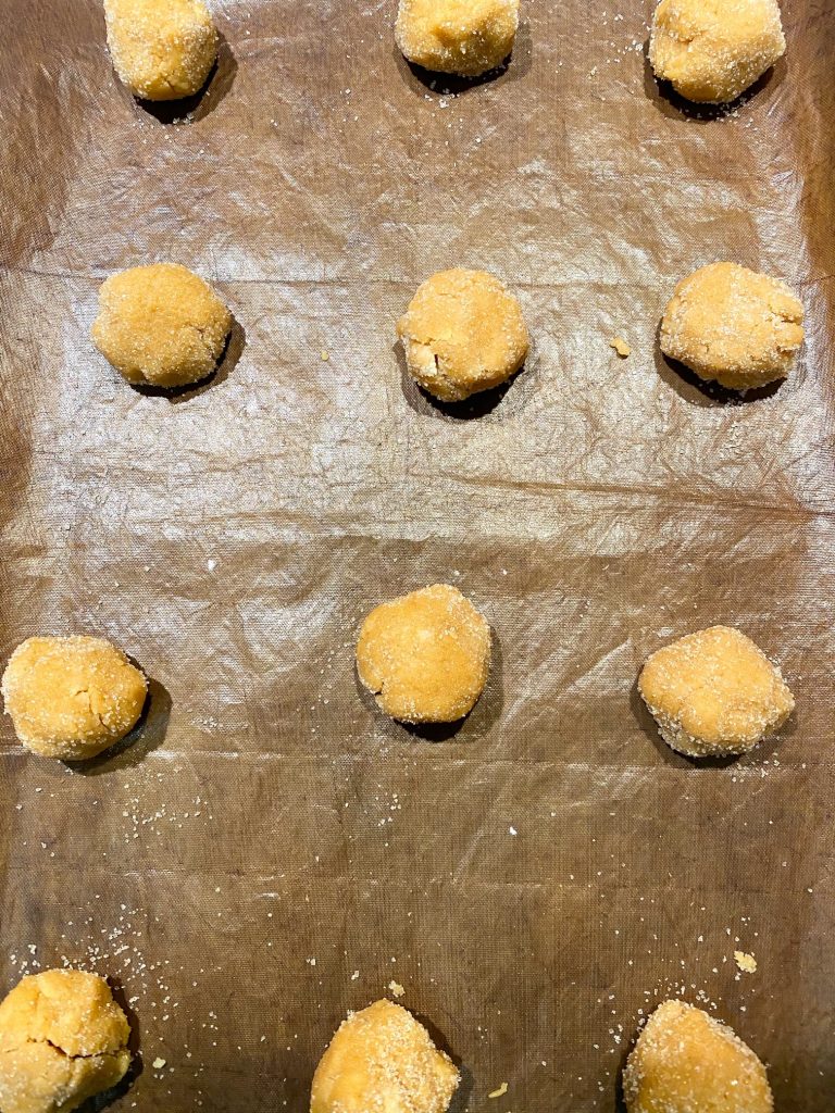 Cookie dough balls on wax paper.