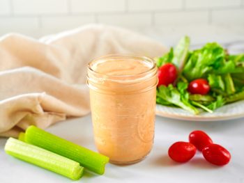 vegan thousand island dressing in jar with salad in the background