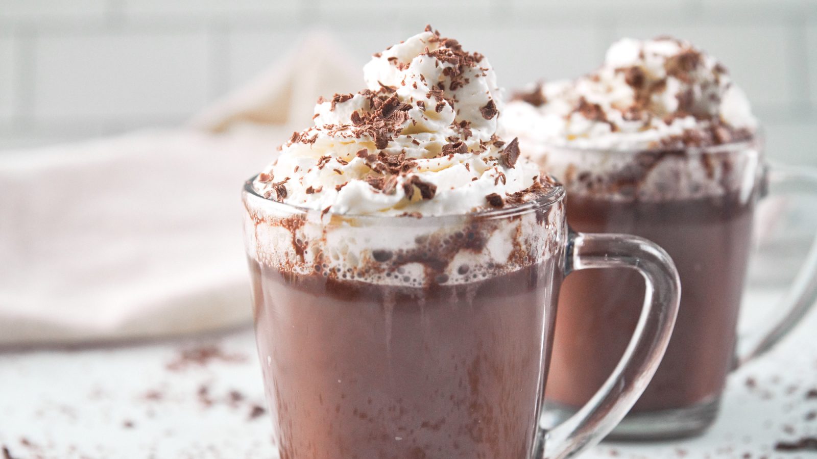 two mugs of vegan hot chocolate with whipped topping