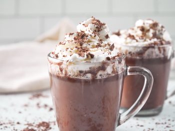 two mugs of vegan hot chocolate with whipped topping