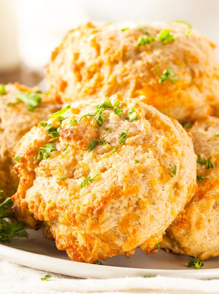 pile of vegan cheddar biscuits with parsley for garnish