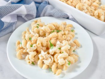brie mac and cheese on a plate with a baking dish in the background