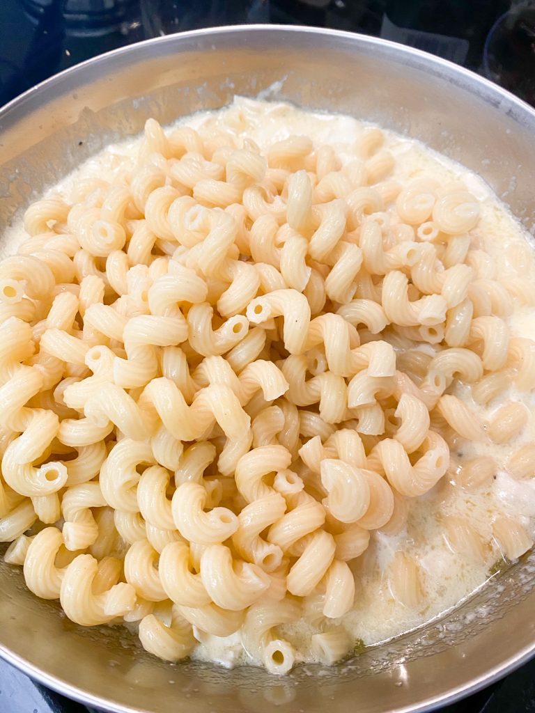 Spiral noodles dumped into the melted brie cheese.