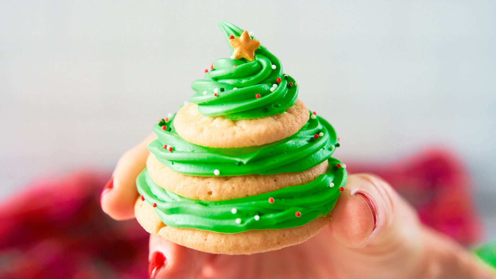 hand holding a stacked sugar cookie christmas tree