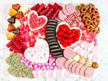 close up of a valentines day charcuterie board with cookies and candy