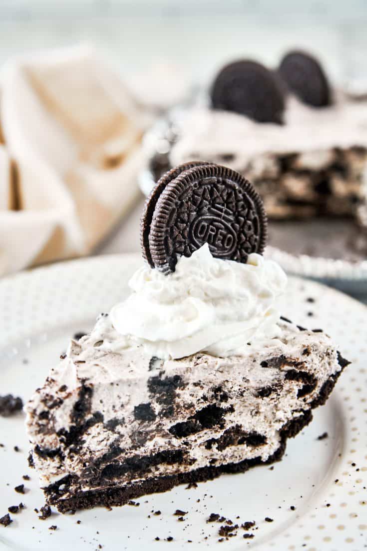 slice of no-bake vegan Oreo cheesecake with whipped topping on plate