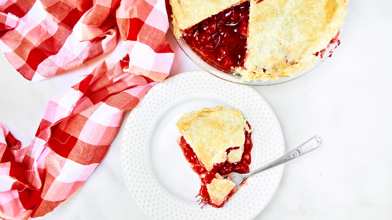 above photo of vegan cherry pie with a slice and a fork