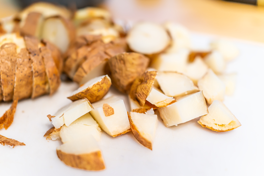 close up of russet potatoes cut up and boiled with the skin on 