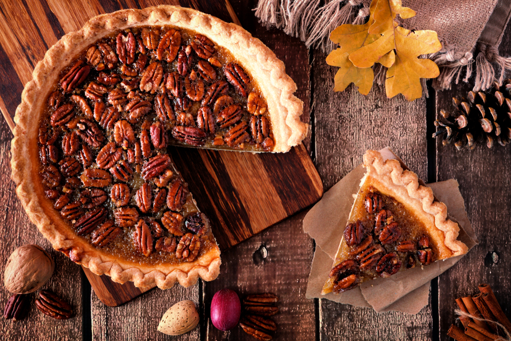 slice of no corn syrup pecan pie on a table with fall decor around it